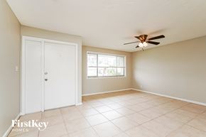 Cape Coral house for rent - A room with a ceiling fan and a door.