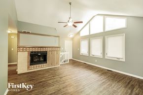 Kansas City house for rent - A spacious living room with a fireplace and wood flooring.