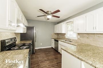 Kansas City house for rent - A kitchen with a stove top oven, refrigerator, and a counter top.