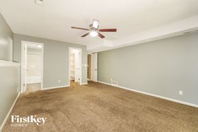 Kansas City house for rent - A spacious room with a carpeted floor and a ceiling fan.