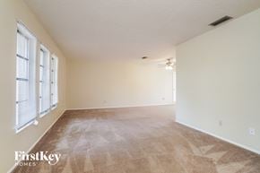 Cape Coral house for rent - A room with a carpeted floor and a window with blinds.