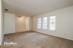 Cape Coral house for rent - A room with a carpeted floor and a window with blinds.