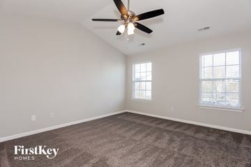 Charlotte house for rent - a living room with carpet and a ceiling fan