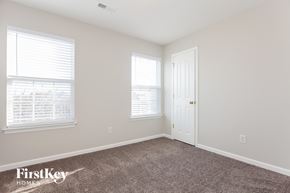 Charlotte house for rent - a bedroom with carpet and two windows and a door