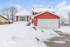 Homer Glen house for rent - A red house with a white garage door in the snow.