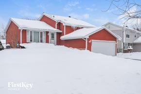 Homer Glen house for rent - A red house with a white garage door in the snow.