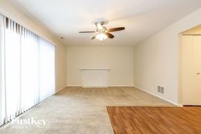 Homer Glen house for rent - A spacious room with a ceiling fan and a large window with curtains.