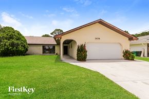 Port St. Lucie house for rent - a home with a white garage door and a lawn