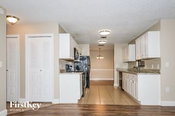 Port St. Lucie house for rent - a kitchen with white cabinets and a black refrigerator