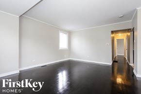 Dolton house for rent - a empty living room with white walls and a black floor