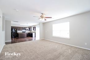 Winston-Salem house for rent - A spacious room with a carpeted floor and a ceiling fan.