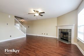 Greenwood house for rent - a living room with a fireplace and a ceiling fan