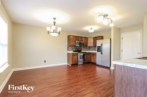 Greenwood house for rent - a kitchen and living room with wood flooring and stainless steel appliances