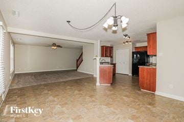 Greenwood house for rent - A kitchen area with a tile floor and a dining area with a table and chairs.