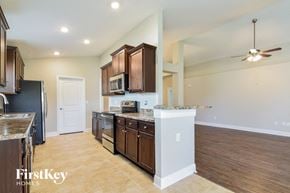 Wimauma house for rent - a kitchen with wooden cabinets and stainless steel appliances