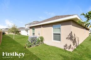 Wimauma house for rent - a beige house with a yard and grass
