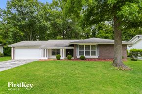 Florissant house for rent - a white and brick house with a yard and a tree