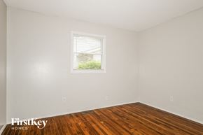 Florissant house for rent - the bedroom of a home with wood floors and a window