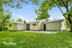 Florissant house for rent - a white and green house with a yard and trees