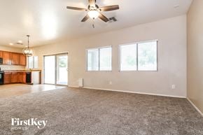 Surprise house for rent - A spacious room with a ceiling fan and a carpeted floor.