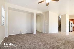 Surprise house for rent - A spacious living room with a carpeted floor and a ceiling fan.