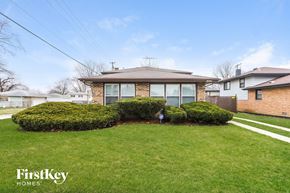 Dolton house for rent - a brick house with a lawn and some bushes