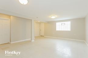 Dolton house for rent - a spacious living room with white tile flooring and a window