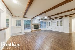 Houston house for rent - A spacious room with wooden floors and a fireplace.