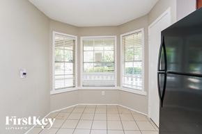 Houston house for rent - a small living room with three windows and a refrigerator