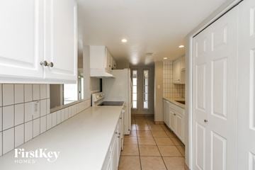 Phoenix house for rent - a large white kitchen with white cabinets and white counter tops
