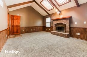 Grandview house for rent - a large empty living room with a fireplace and a door