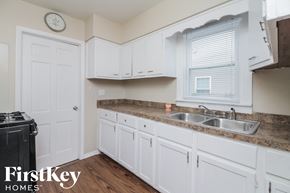 Midlothian house for rent - a kitchen with white cabinets and a counter top and a sink