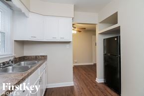 Midlothian house for rent - a kitchen with white cabinets and a black refrigerator