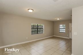 Miami house for rent - A spacious empty room with a window and a door.