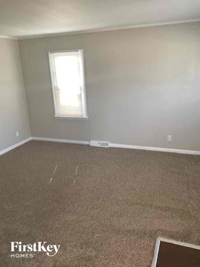 Dolton house for rent - an empty room with a carpeted floor and a window