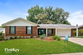 Florissant house for rent - a small brick house with a lawn and a driveway