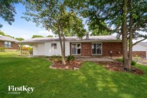 Florissant house for rent - a small white house with a yard and trees