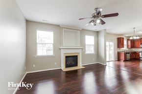 Charlotte house for rent - A spacious living room with a fireplace and a ceiling fan.