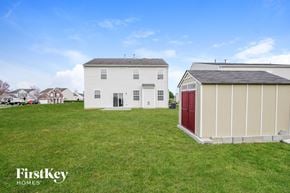 Charlotte house for rent - A white house with a red door is situated in a grassy field.