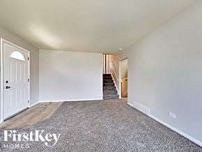 Dolton house for rent - a living room with a carpeted staircase and a white door