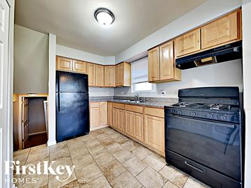 Dolton house for rent - a kitchen with black appliances and wooden cabinets