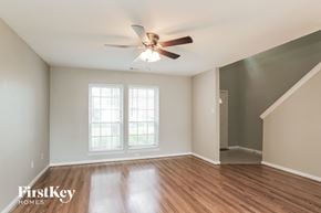 Houston house for rent - A room with a ceiling fan and wooden floors.
