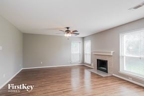Houston house for rent - A spacious room with a fireplace and a ceiling fan.