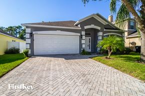 Orlando house for rent - a white garage door on a brick driveway in front of a house