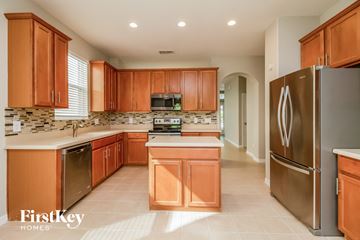 Orlando house for rent - a kitchen with wooden cabinets and stainless steel appliances