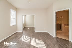 Orlando house for rent - a spacious living room with wood flooring and a door to a bathroom