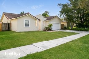 Miami house for rent - a home with a lawn and a sidewalk in front of it