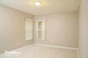 Miami house for rent - a spacious living room with white tile floors and a window
