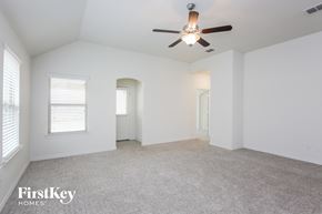 Haslet house for rent - a spacious living room with white walls and a ceiling fan