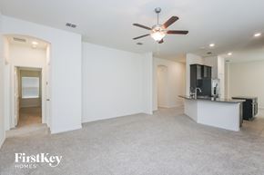 Haslet house for rent - an empty living room with a kitchen and a ceiling fan